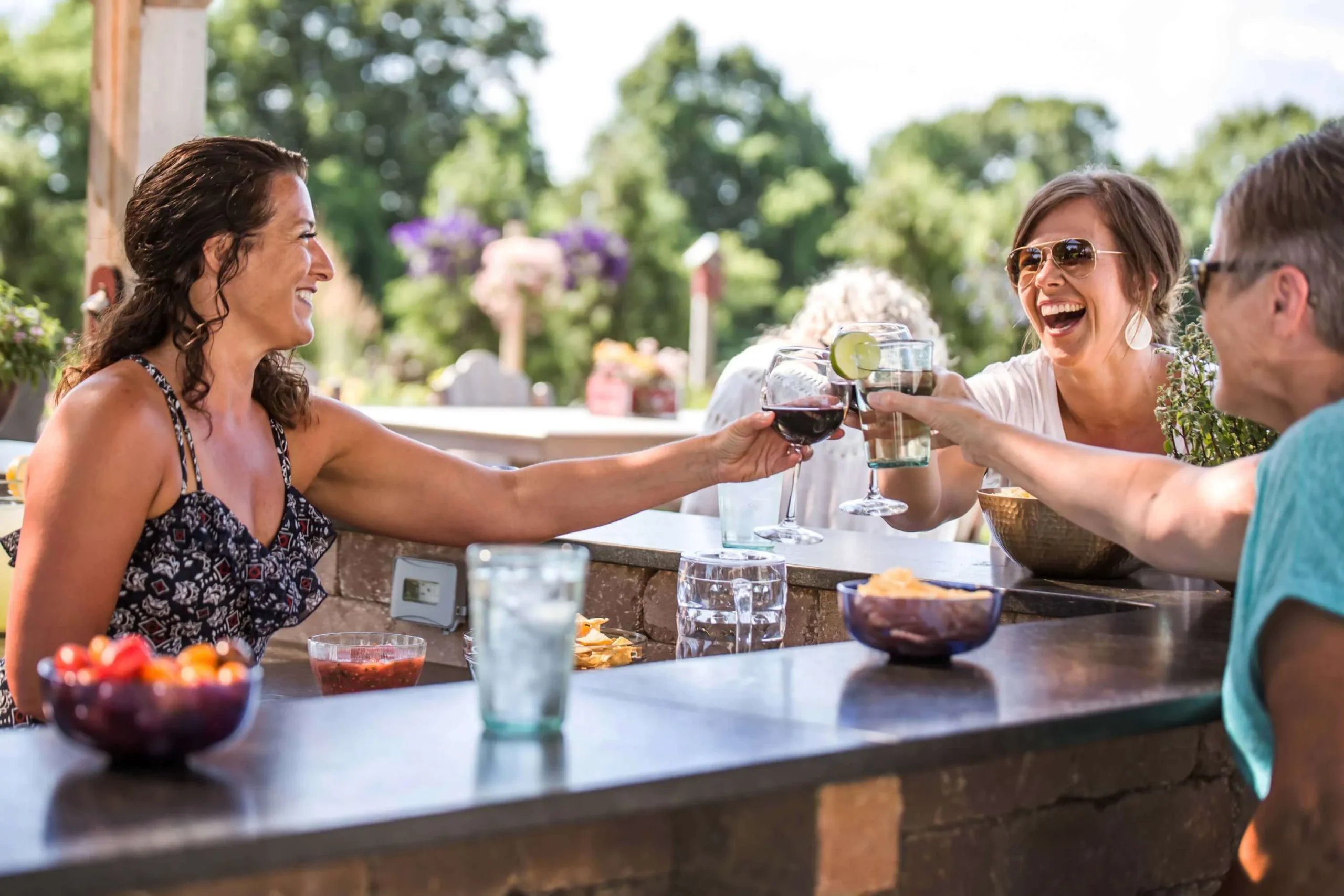 family sitting together with drinks around a patio bar