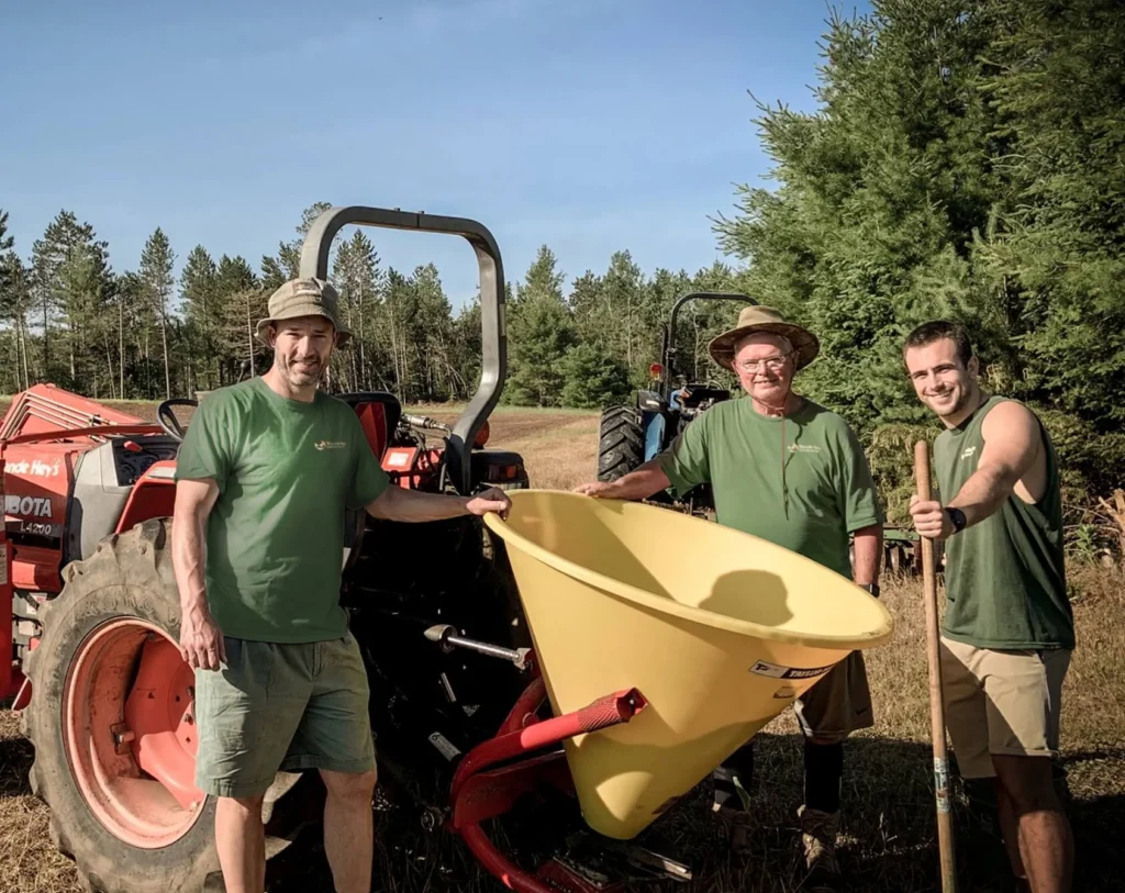 three people standing around tractor